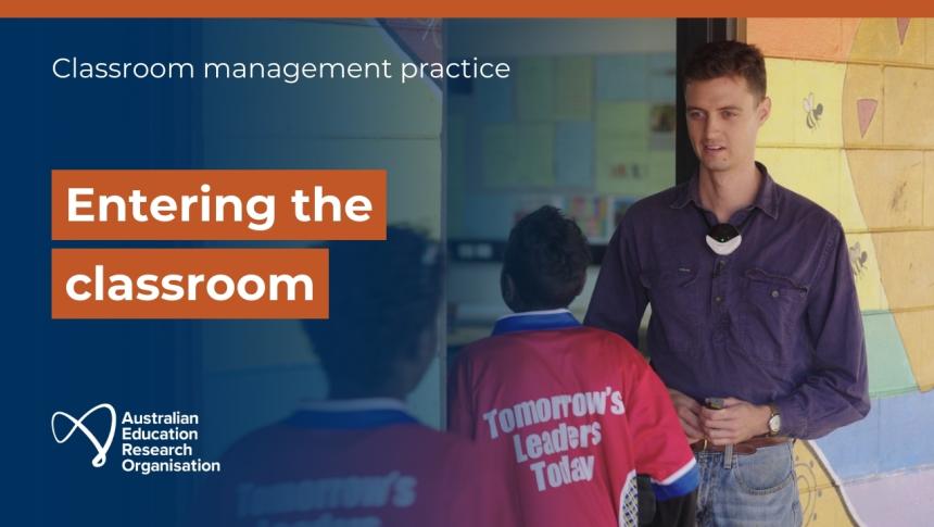 A screenshot from the video of a teacher standing in the doorway of a classroom as students enter.