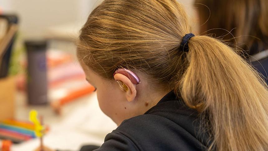 Student writing at desk