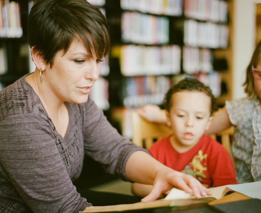 Teacher and young student reading