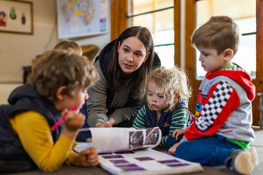 An educator with three preschool students. 